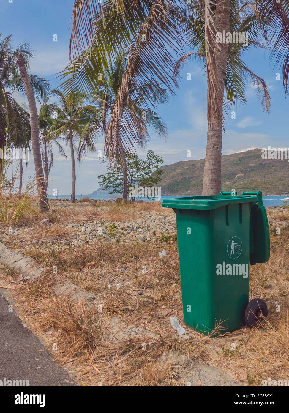 Aperto grande vuoto plastica rifiuti bidone in moderno villaggio vicino mare e palme. Controllo infettivo, smaltimento rifiuti, smaltimento di Foto Stock