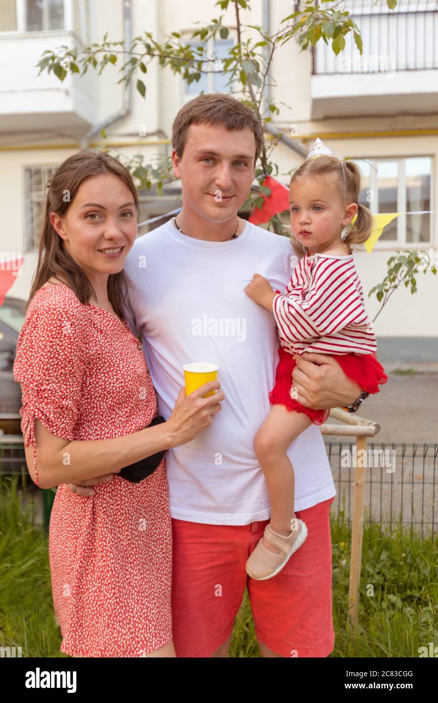 Famiglia giovane positiva con bambino in piedi sulla strada Foto Stock