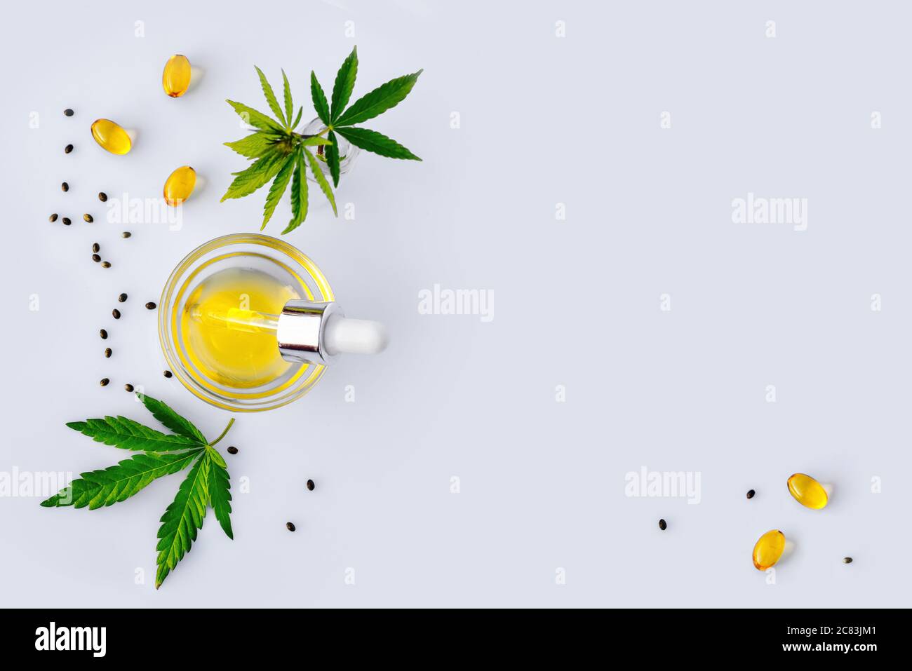 Olio CBD, tintura di canapa con pipetta su fondo bianco con foglie di cannabis Foto Stock
