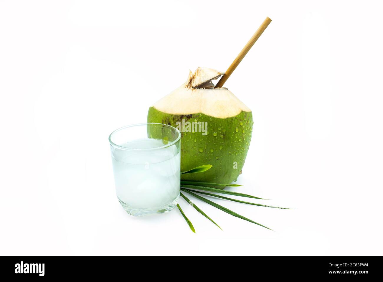 Un bicchiere di acqua di cocco con cocco verde su sfondo bianco. Foto Stock