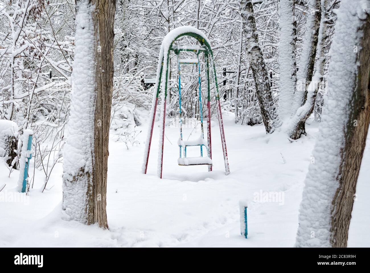 Altalene abbandonate per bambini, abbondantemente coperte di neve nel parco invernale Foto Stock