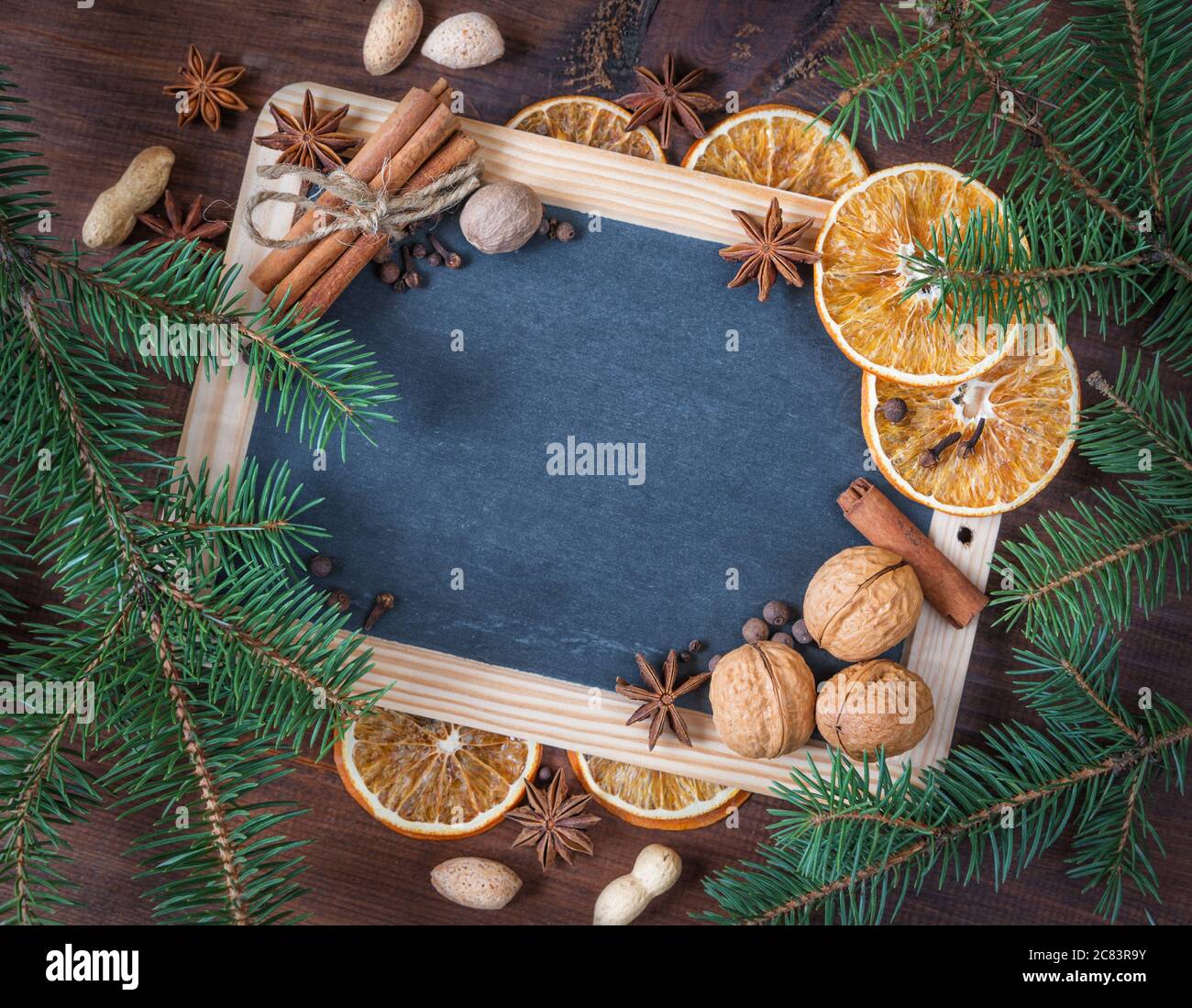 Lavagna vuota circondata da rami di abete verde e varie spezie come cornice natalizia con spazio per la copia Foto Stock