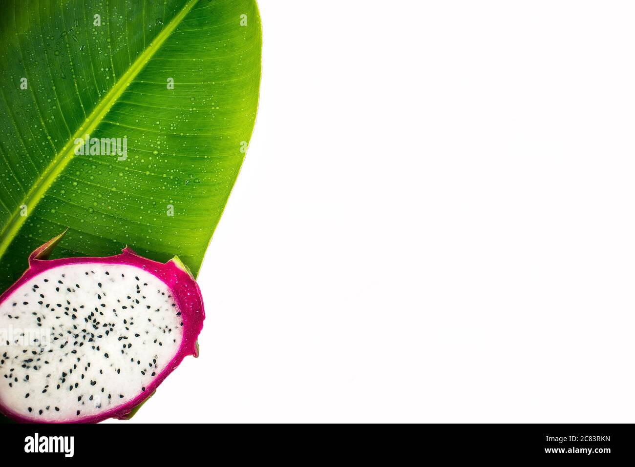 Frutto del drago su una foglia di banana isolata su sfondo bianco. Foto Stock