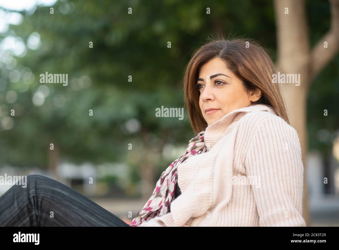 Malinconici donna che guarda lontano all'aperto Foto Stock