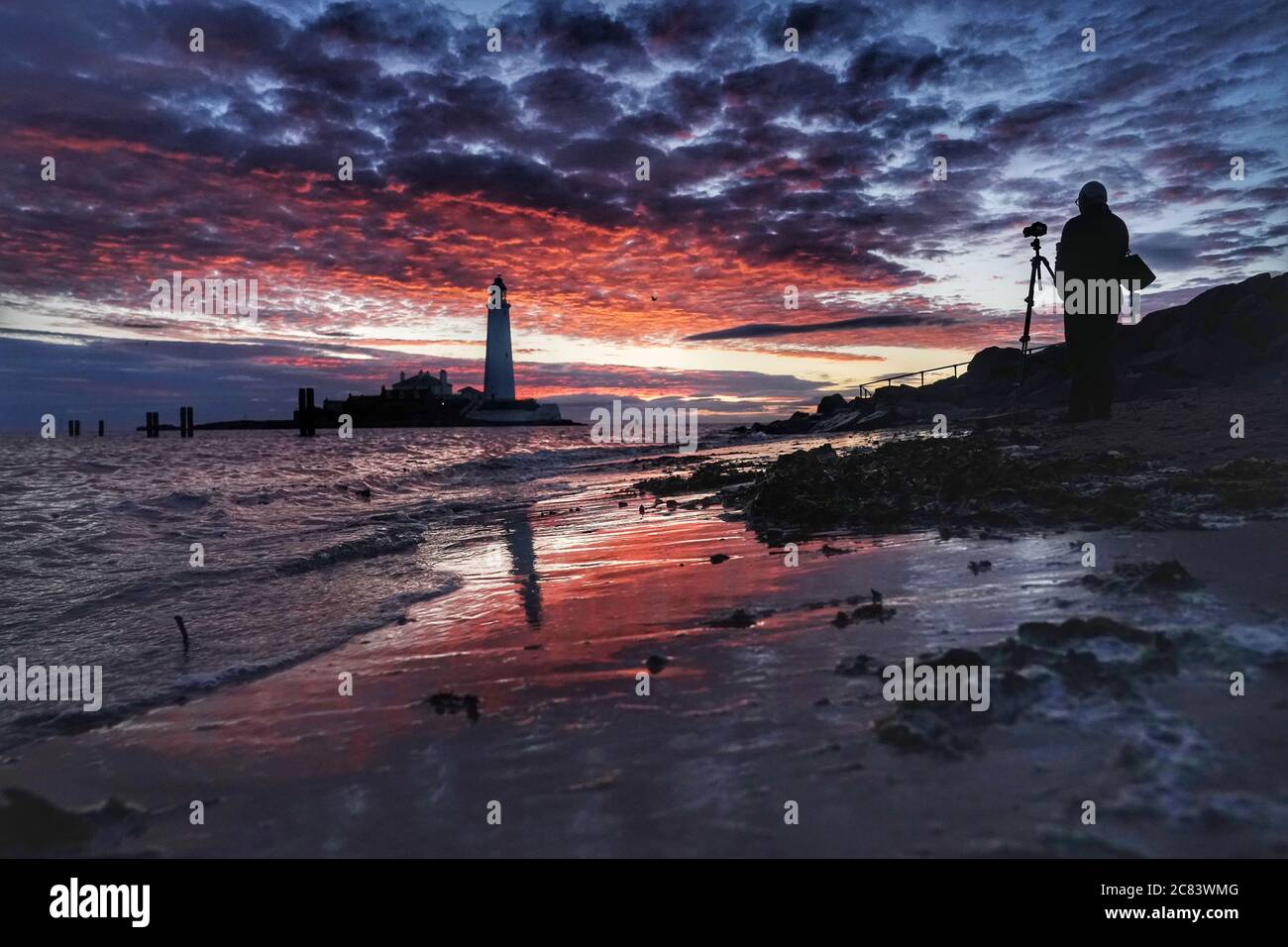 Un fotografo si allinea con il suo scatto a Dawn al faro di St Mary a Whitley Bay nelle prime ore del martedì mattina. Data immagine: Martedì 21 luglio 2020. Il credito fotografico dovrebbe essere: Owen Humphreys/PA Wire Foto Stock