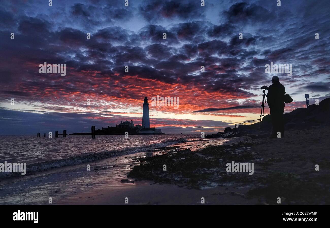 Un fotografo si allinea con il suo scatto a Dawn al faro di St Mary a Whitley Bay nelle prime ore del martedì mattina. Data immagine: Martedì 21 luglio 2020. Il credito fotografico dovrebbe essere: Owen Humphreys/PA Wire Foto Stock