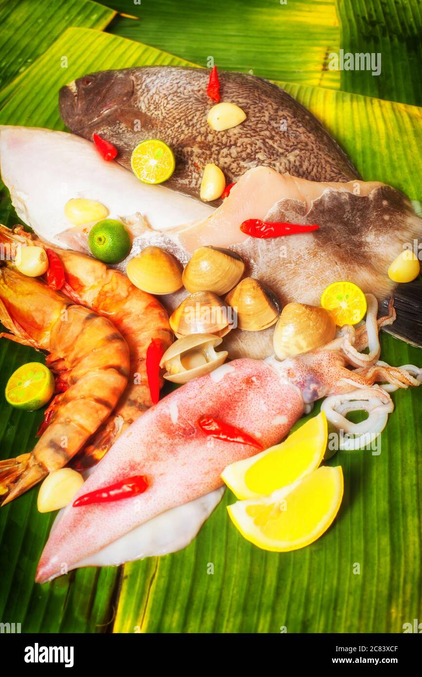 Immagine verticale della visualizzazione di pesce crudo, disposizione sulle foglie di banana, immagine applicare con filtro per creare un effetto morbido. Foto Stock
