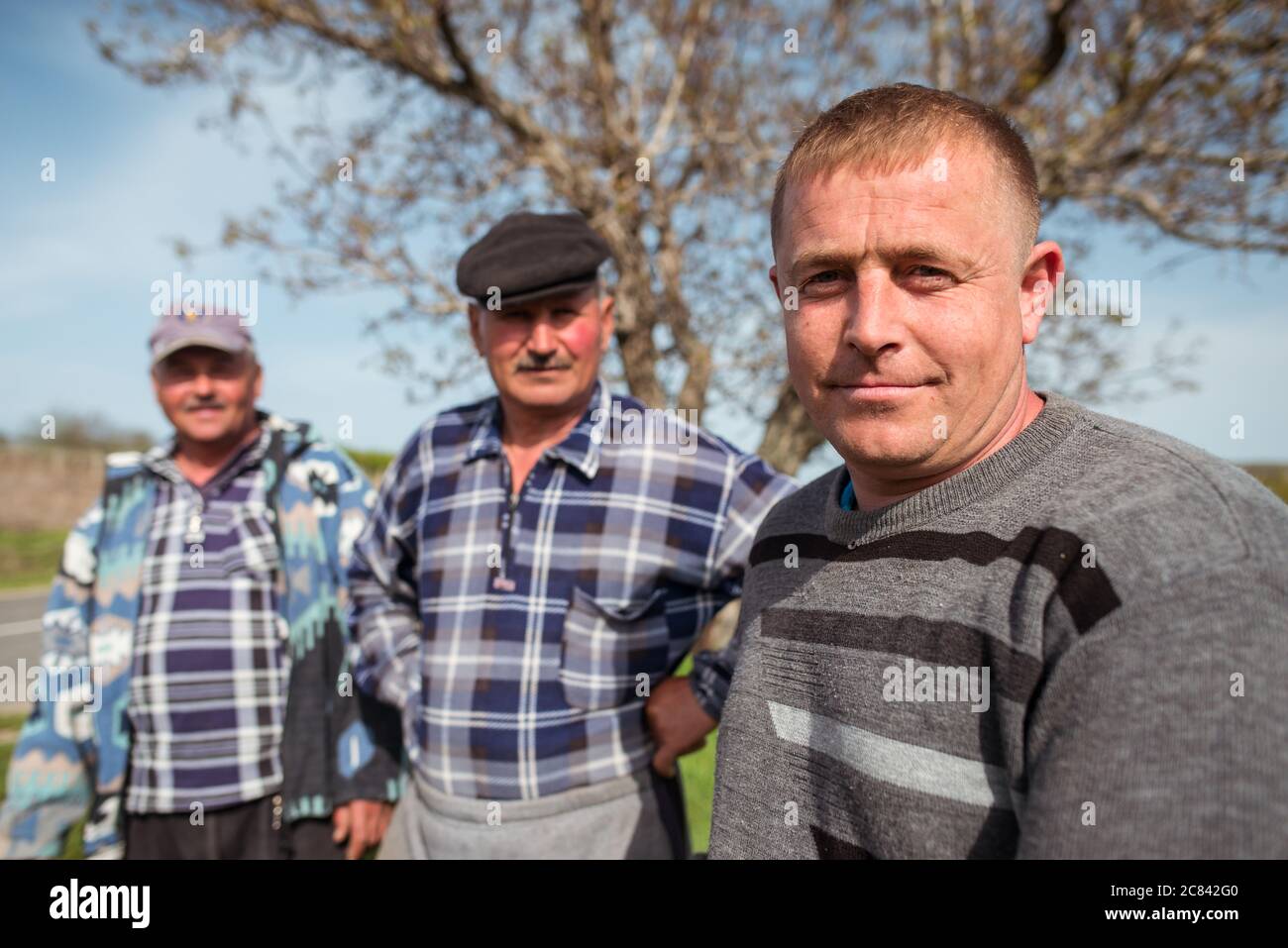 Trebujeni / Moldavia - 15 maggio 2020: Ritratto di agricoltori moldavi in campo accanto alla macchina aratrice vicino a terreni agricoli Foto Stock