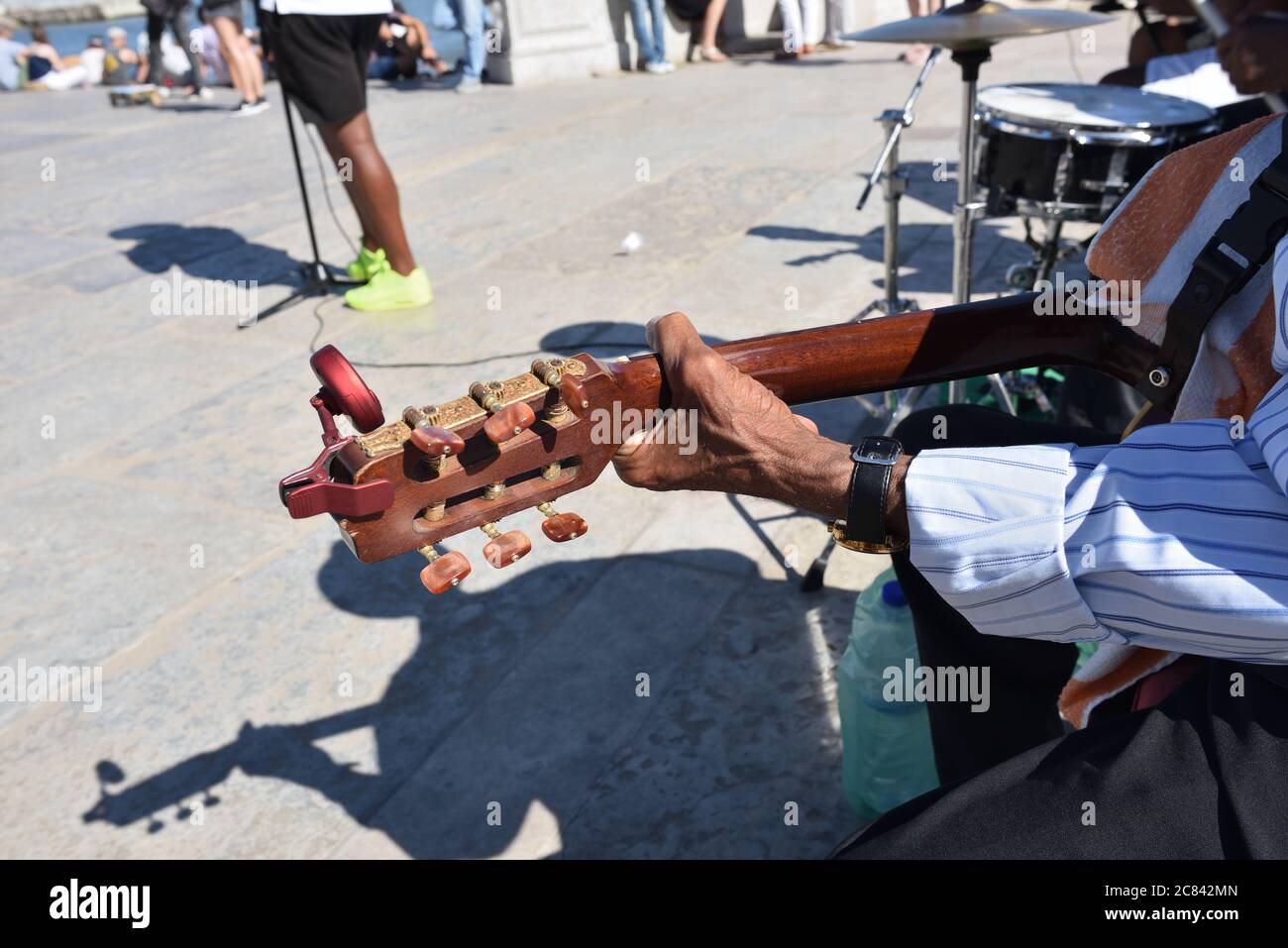 Mano di un musicista di strada senior su una tastiera di chitarra durante lo spettacolo di strada sulla piazza Praca de Comercio (piazza del Commercio), Lisbona, Portogallo Foto Stock