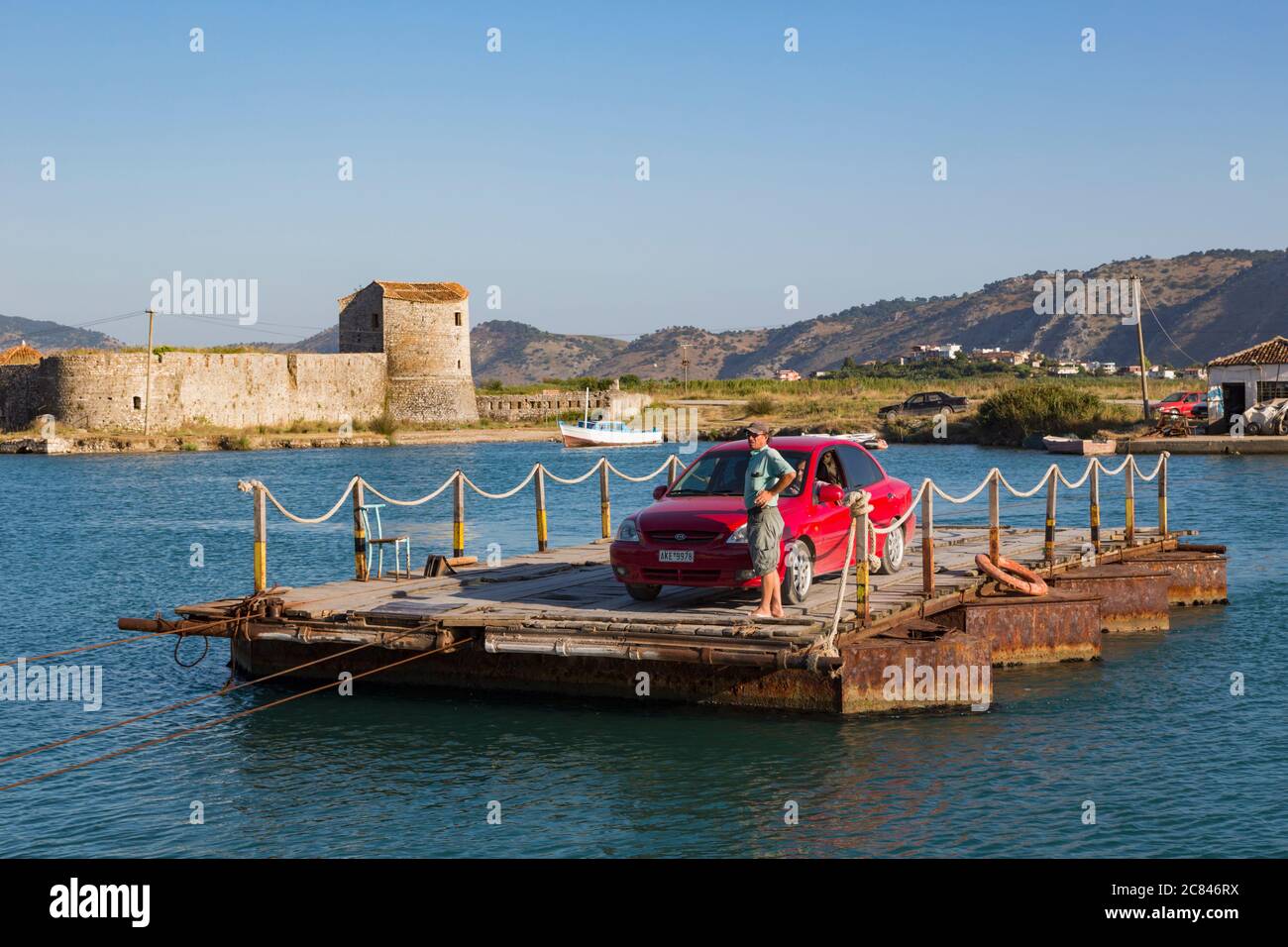 Butrint, Albania. Traghetto che attraversa il canale di Vivari con un'auto. Sullo sfondo la fortezza triangolare del XVI secolo. Parte di un Pa. Nazionale Foto Stock