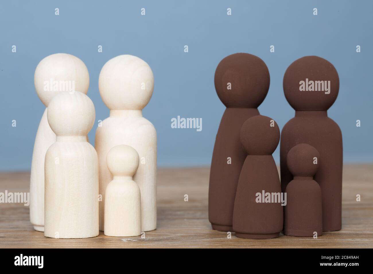 Una famiglia nera e una famiglia bianca che si distinguono in un concetto di minoranza etnica divisa Foto Stock