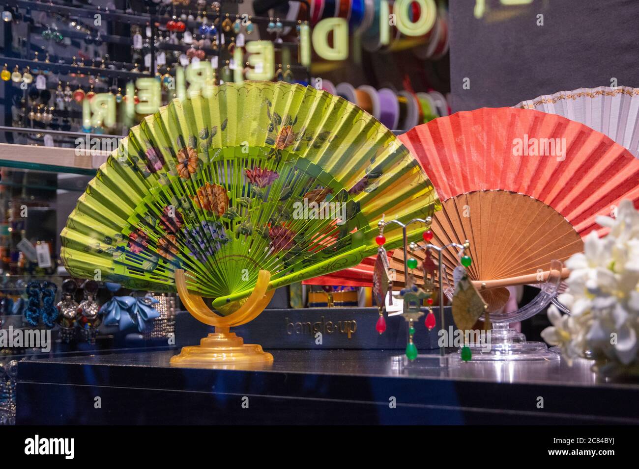 Ventilatore portatile cinese tradizionale con fiori su una vetrina di un negozio di fantasia Foto Stock