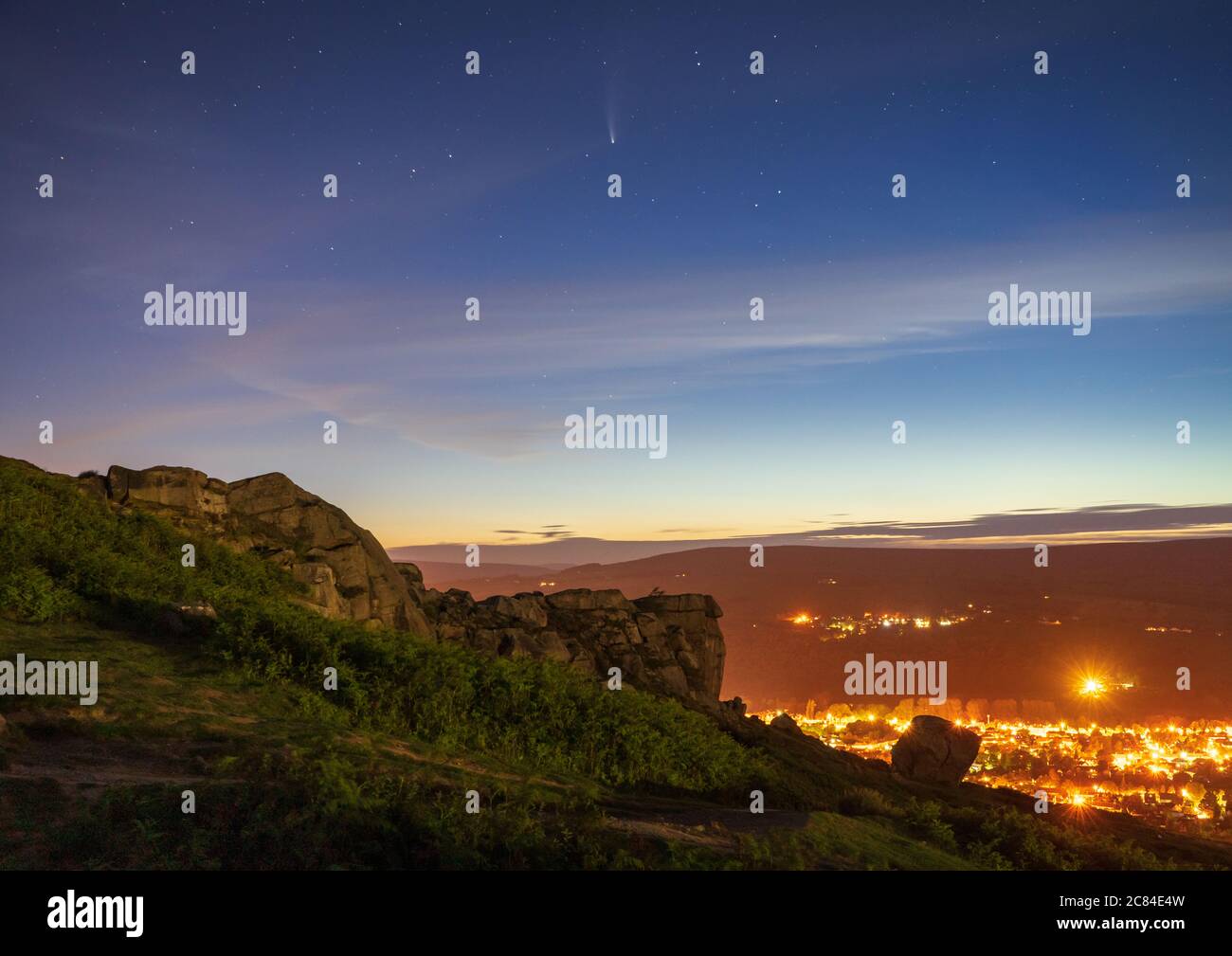 La cometa NEOWISE è visibile nel cielo notturno sopra Ilkley con le famose Cow & Calf Rocks che offrono interesse in primo piano. Foto Stock