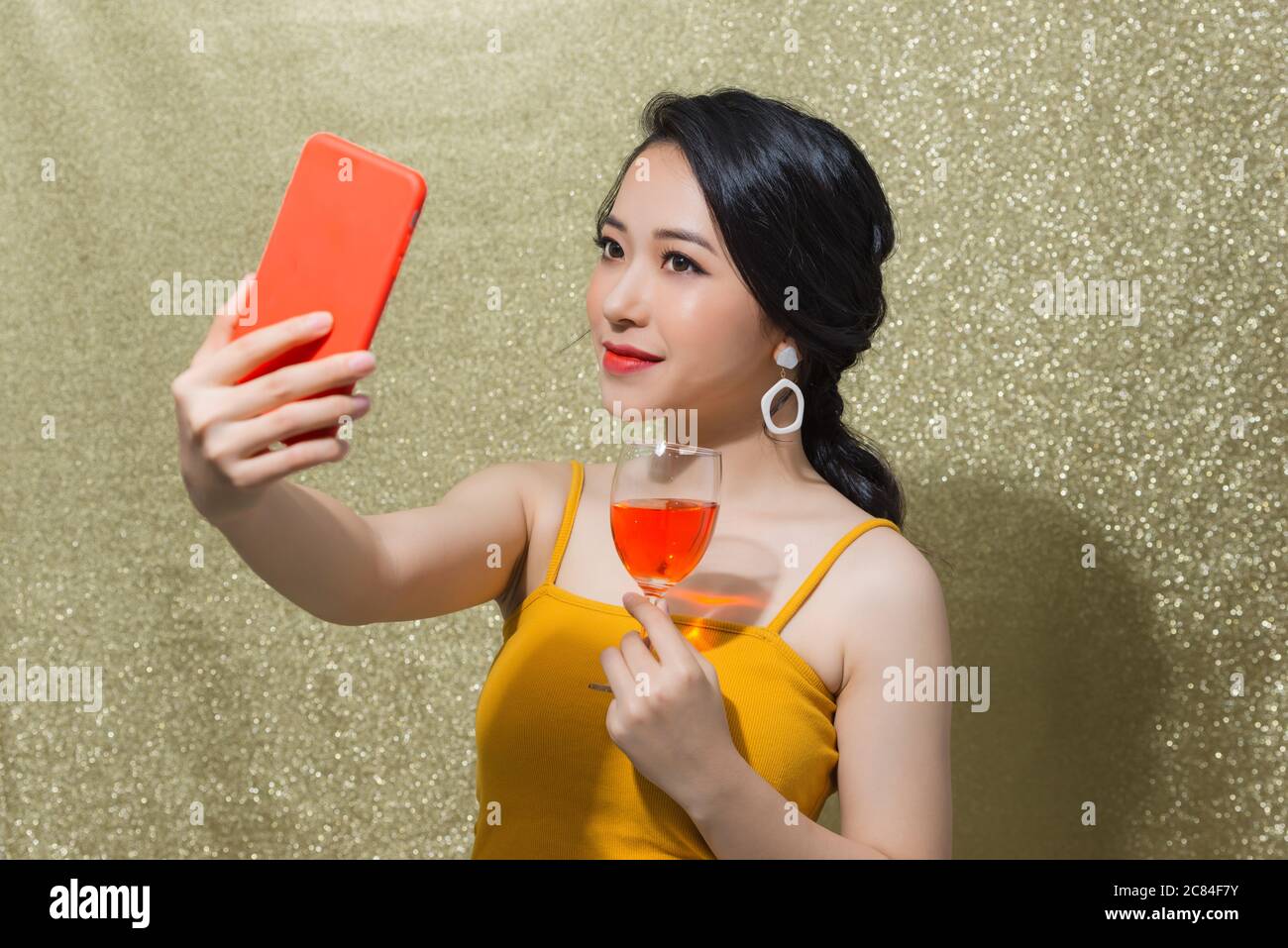 Festa. Bella giovane donna asiatica che fa selfie sul telefono in 'party' occhiali. Foto Stock