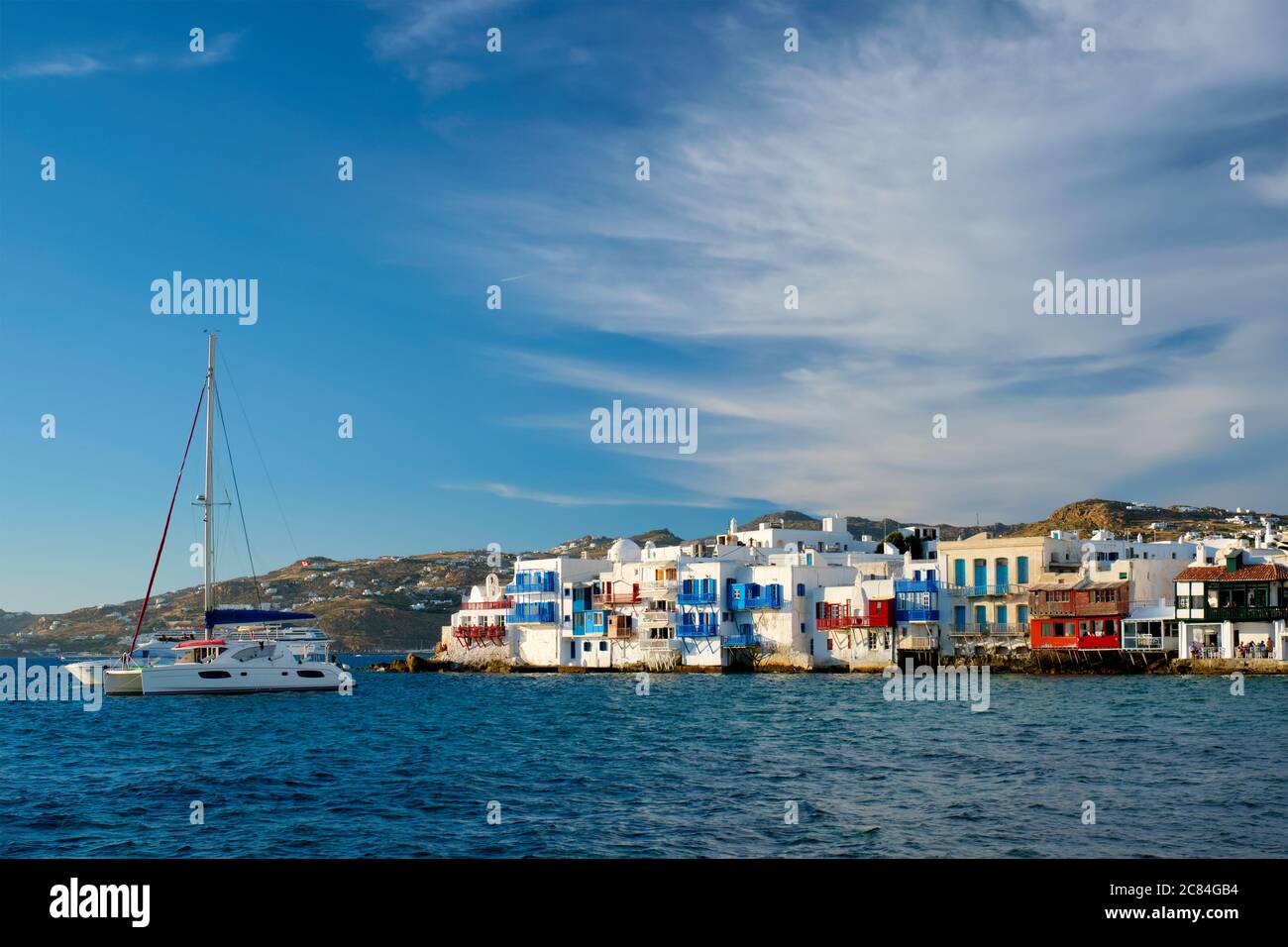 Tramonto a Mykonos, Grecia, con nave da crociera e yacht nel porto Foto Stock