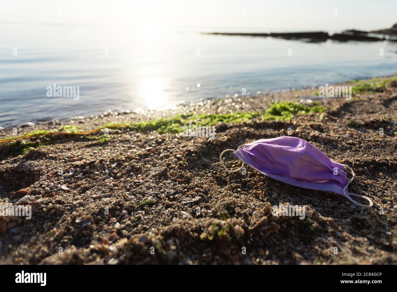 Wasted Medical Mask sdraiato su inquinata spiaggia all'aperto, spazio libero Foto Stock