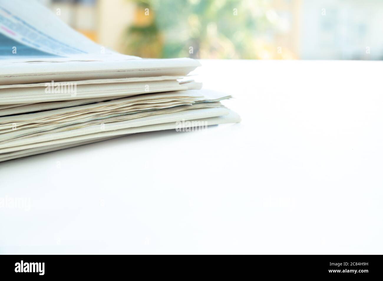 Mucchio di giornali freschi del mattino sul tavolo in ufficio. Perni di banco piegati e impilati Foto Stock