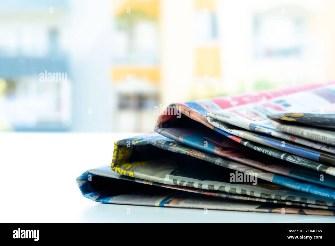 Mucchio di giornali freschi del mattino sul tavolo in ufficio. Perni di banco piegati e impilati Foto Stock