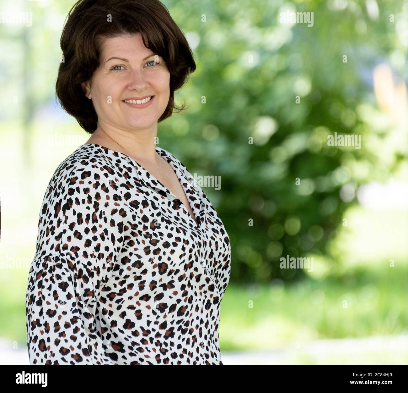 Ritratto di una donna di mezza età in una blusa colorata natura Foto Stock
