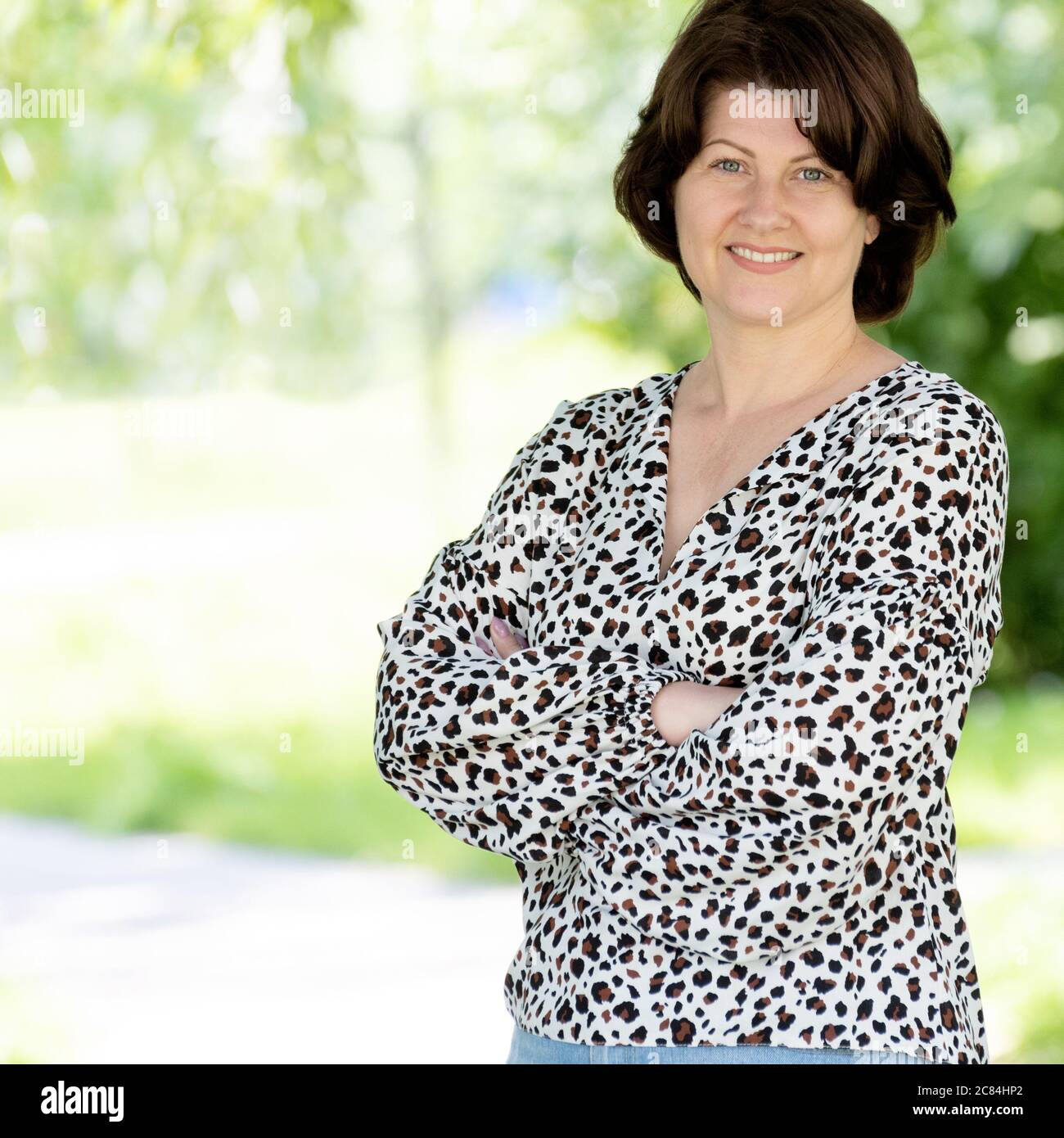 Ritratto di una donna di mezza età in una blusa colorata natura Foto Stock