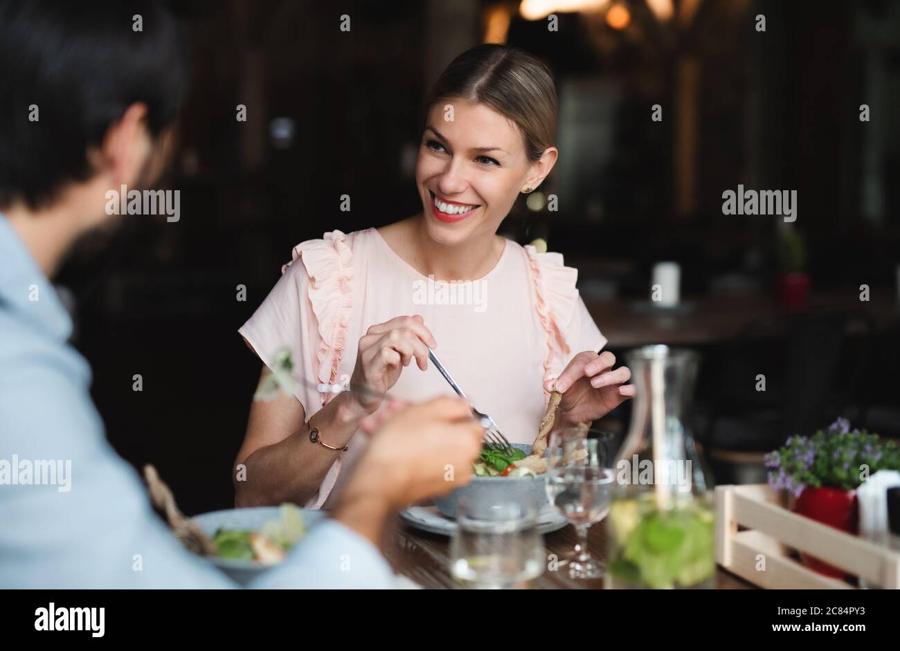 Felice coppia seduta al coperto nel ristorante, mangiare. Foto Stock