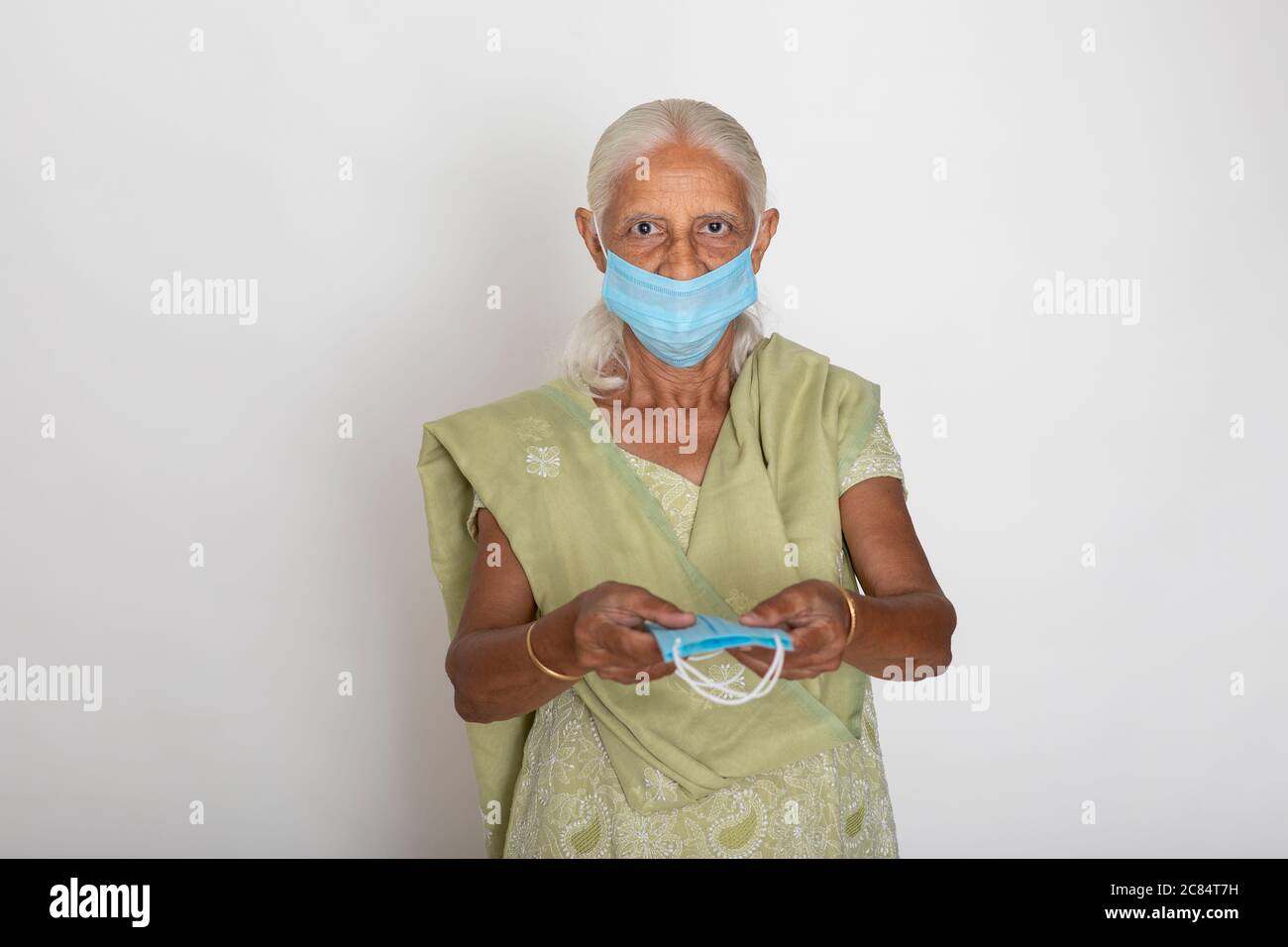 Donna indiana matura che indossa maschera di protezione Covid, nonna indiana mostra maschera di protezione del viso Foto Stock