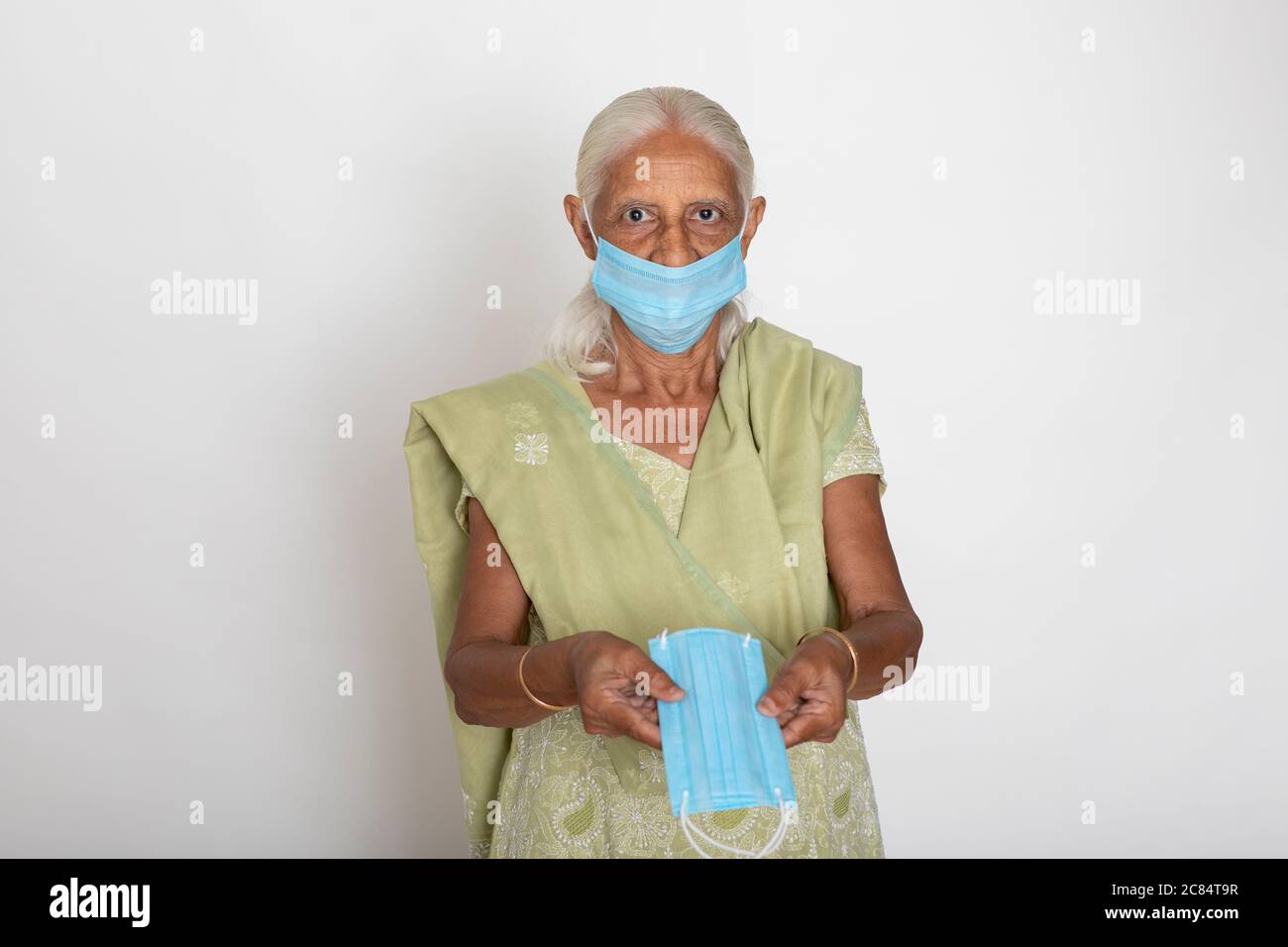 Donna indiana matura che indossa maschera di protezione Covid, nonna indiana mostra maschera di protezione del viso Foto Stock