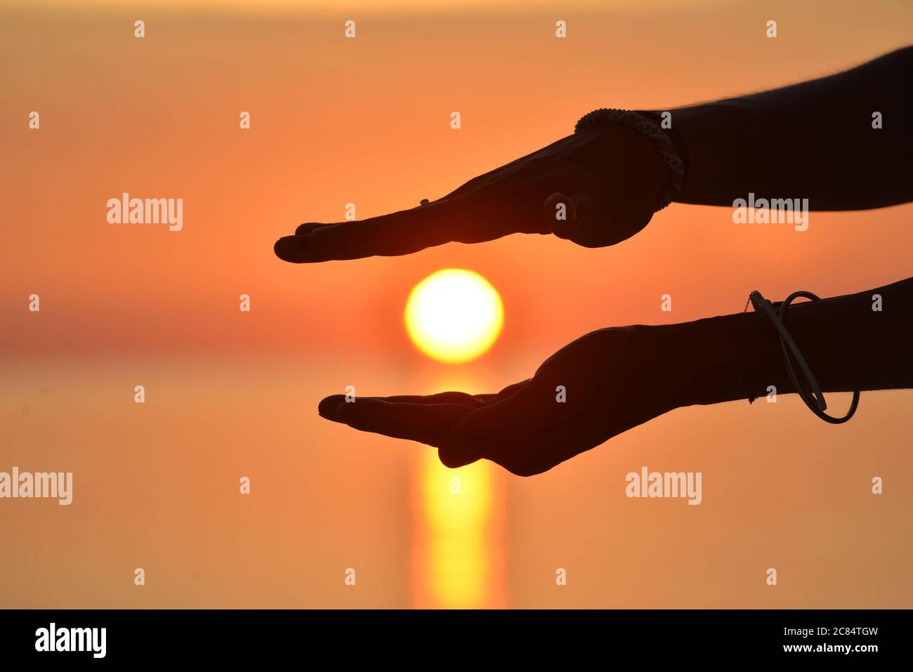 Cuba, provincia di Pinar del Rio: Donna che tiene il sole tramontare con le due mani, sull'isola di Cayo Lebisa Foto Stock