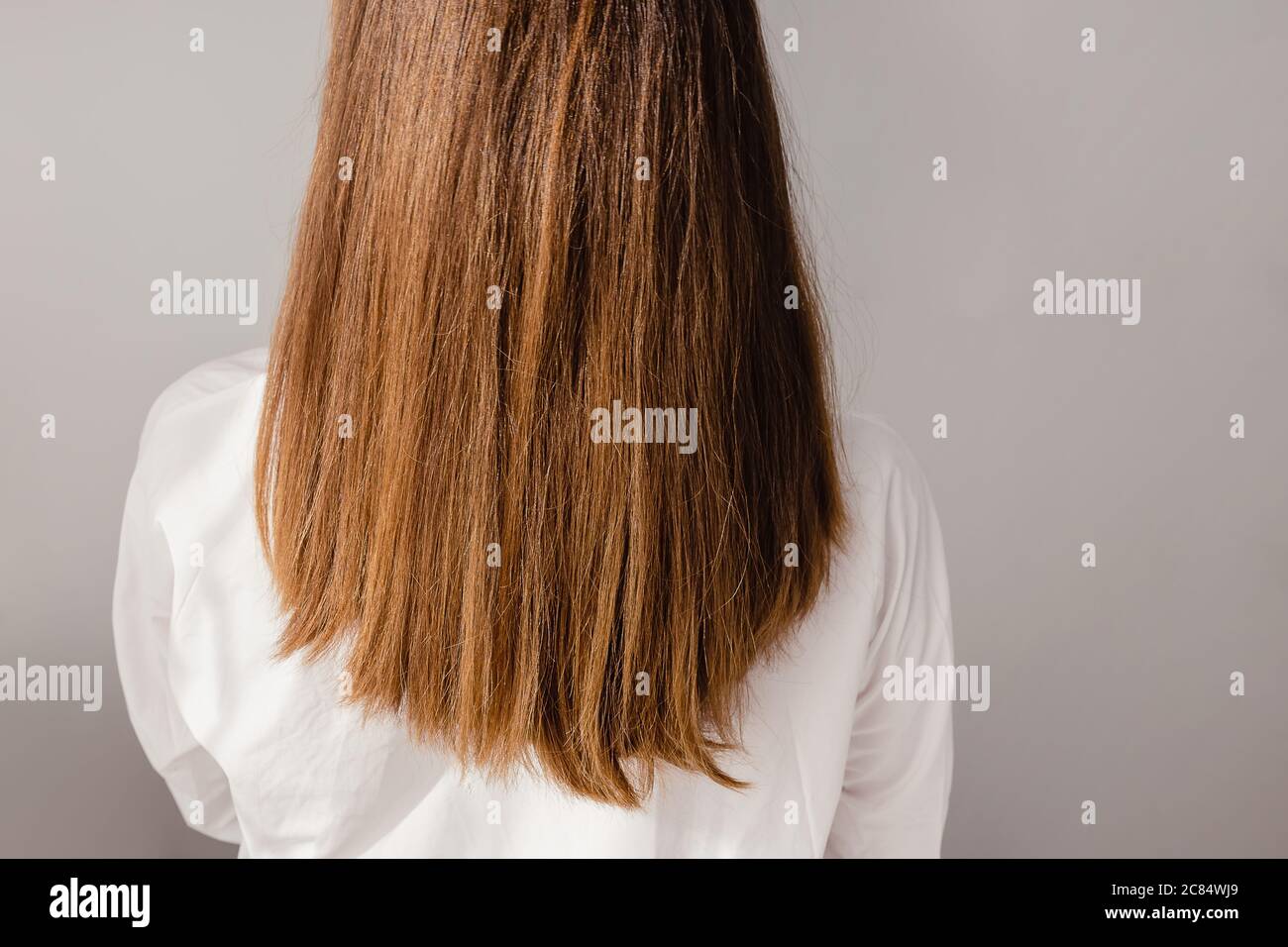 Vista posteriore di una giovane donna in camicia bianca con un'udito lungo e brillante. Foto Stock