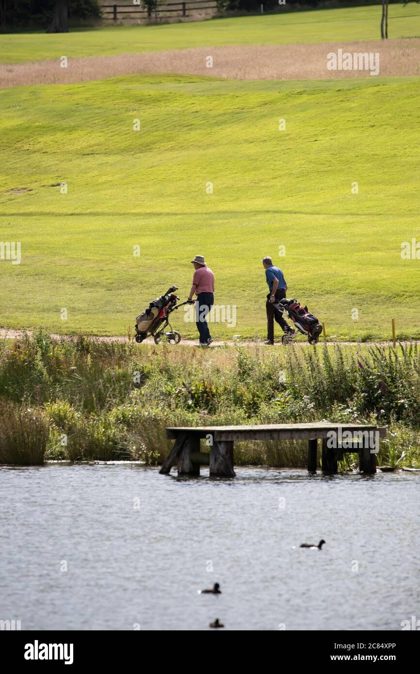 Due golfisti maschi che giocano una partita a due palline sul campo da golf Meltham vicino a Huddersfield in una giornata estiva soleggiata Foto Stock