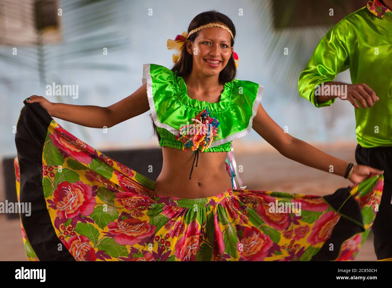 La variopinta danzatrice popolare ragazza tiene fuori le pieghe del suo vestito esotico durante una esposizione locale di ballo in Alter do Chao, Stato di Para, Brasile Foto Stock