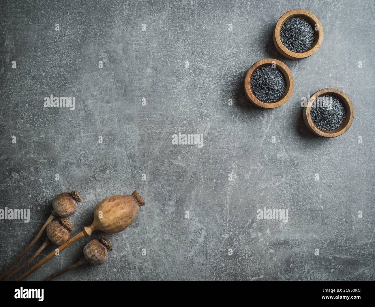 Teste di papavero asciutte e semi di papavero in ciotole di legno. Foto a soffitto con spazio per la copia. Foto Stock