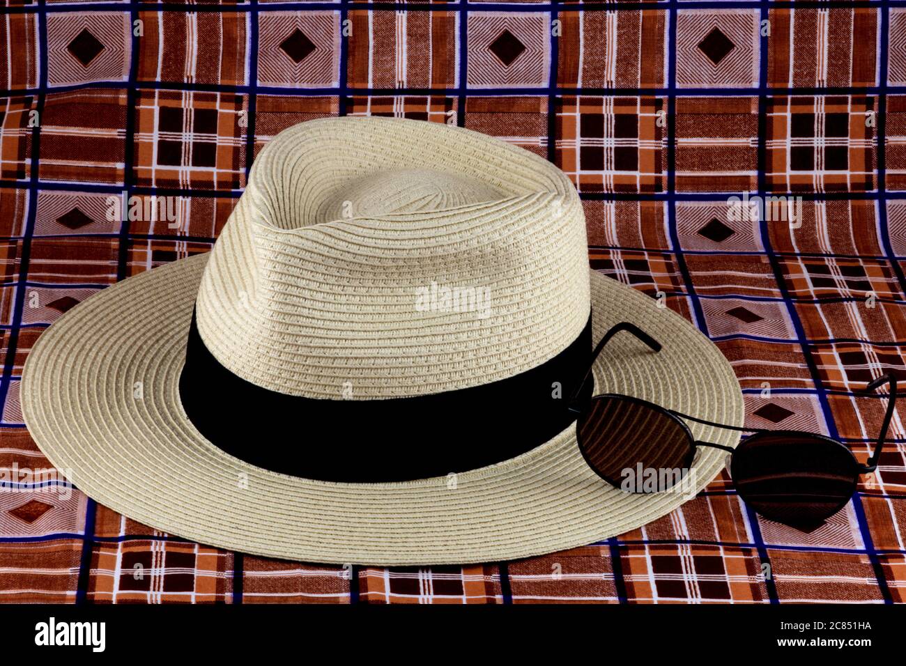 Cappello di paglia Panama con occhiali da sole su un sarong spiaggia  colorato Foto stock - Alamy