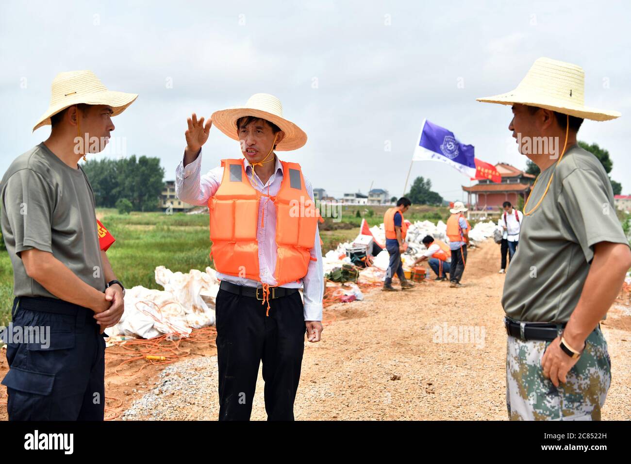 (200721) -- JIUJIANG, 21 luglio 2020 (Xinhua) -- il professor Deng Juzhi (C) comunica con il personale locale di controllo delle inondazioni sulla diga interna del fiume Furong nella città di Furongdun di Jiujiang, nella provincia di Jiangxi, nella Cina orientale, 21 luglio 2020. La diga interna del fiume Furong ha visto continui problemi di tubatura a causa di un gran numero di nidi di formiche in esso, che rappresentano una grave minaccia per la sicurezza dei residenti locali. Credit: Xinhua/Alamy Live News Foto Stock