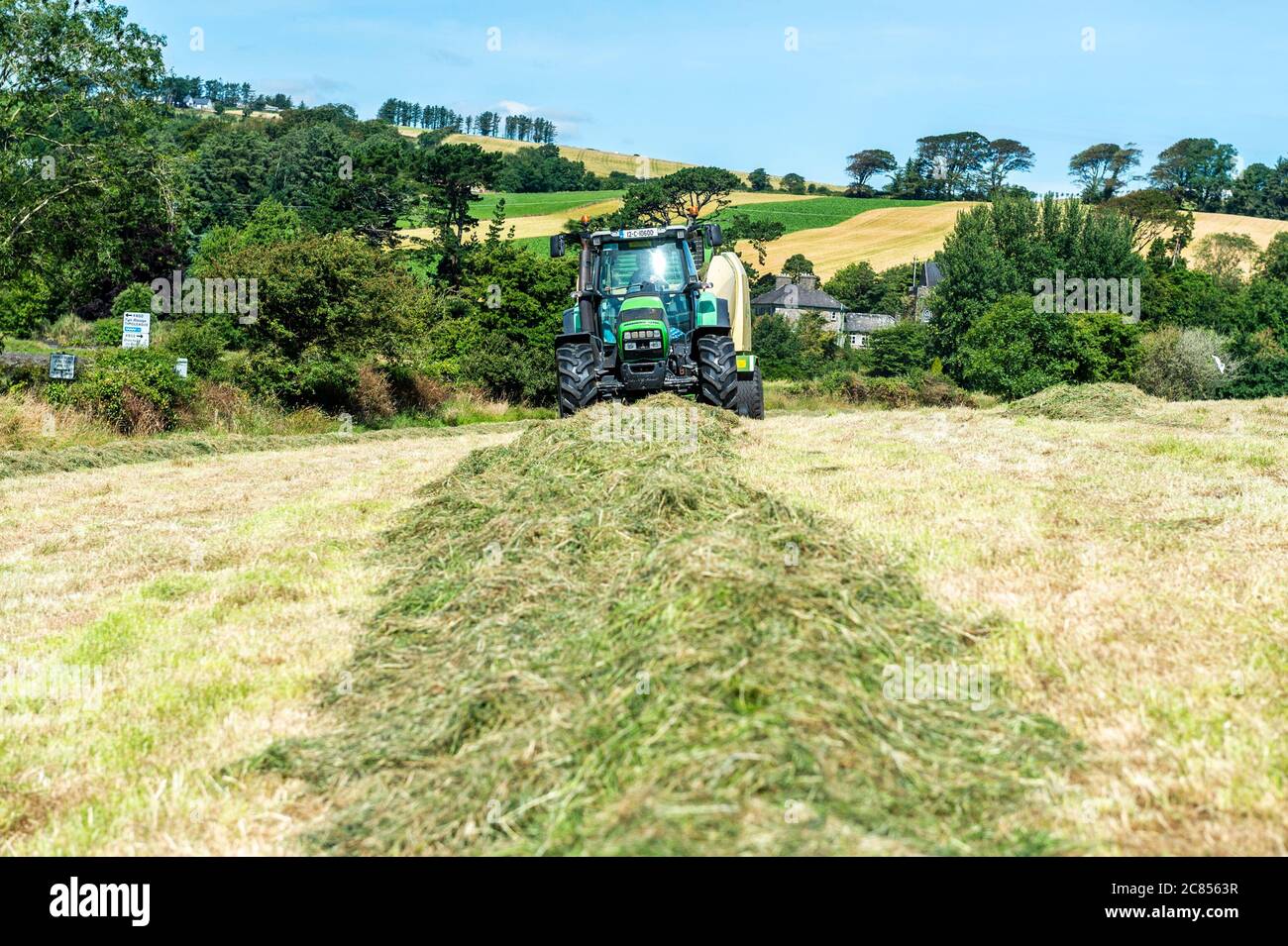 Timoleague, West Cork, Irlanda. 21 luglio 2020. In una giornata di caldo, sole e alti di 22 gradi Celsius, Michael e Richard McCarthy Bale insilato nella loro fattoria a Timoleague, West Cork. Credit: Notizie dal vivo di AG/Alamy. Foto Stock