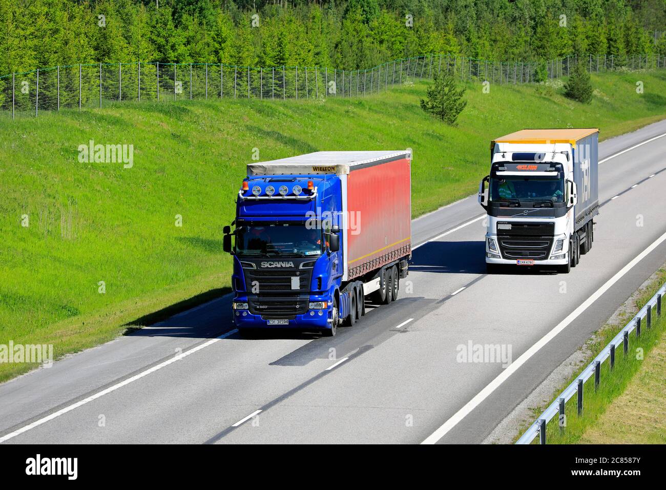 Il semirimorchio Volvo FH bianco supera il semirimorchio Scania blu con carico più pesante. Salo, Finlandia. 12 giugno 2020. Foto Stock