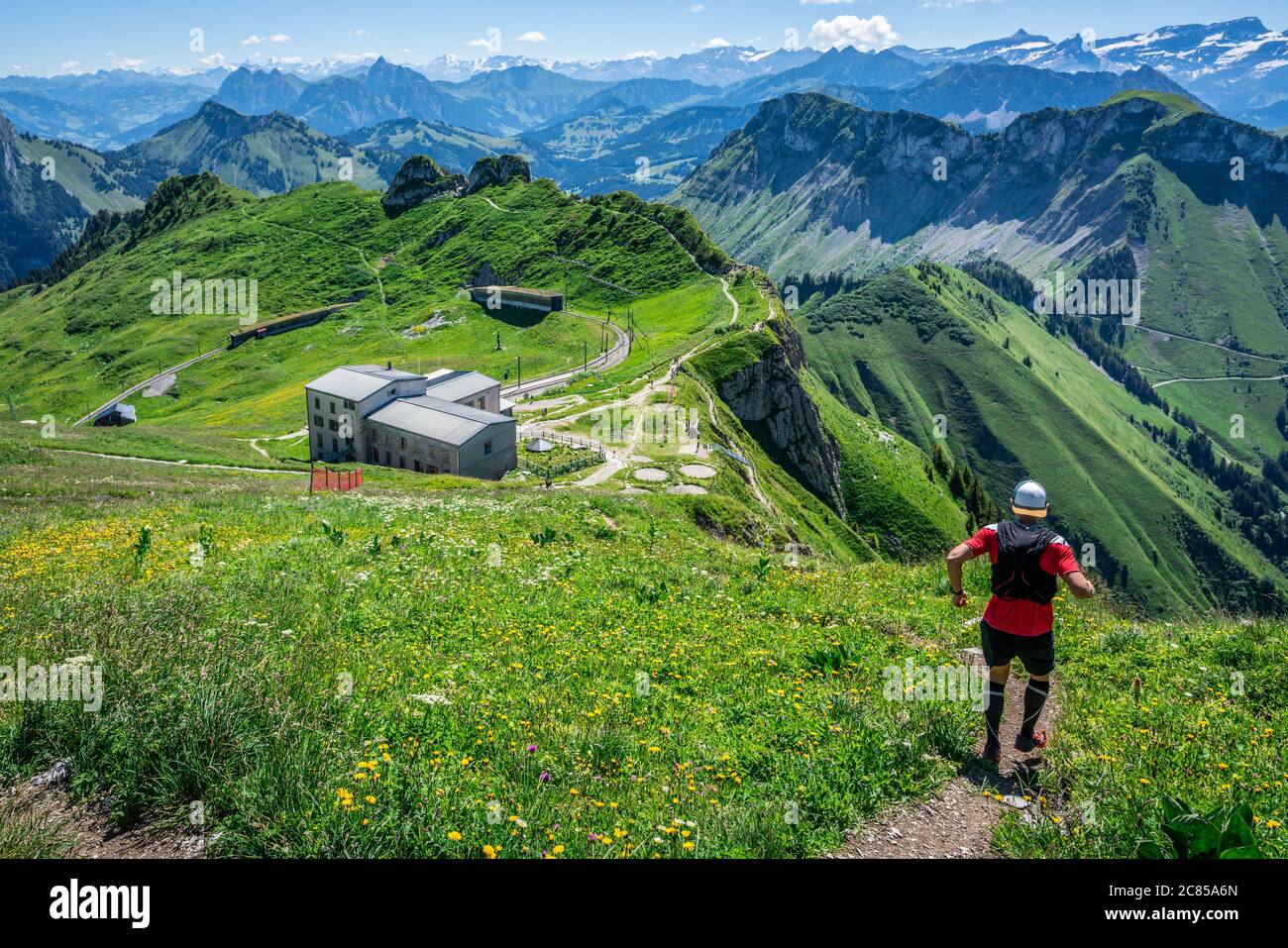 Uomo che inizia una pista discesa in Alpi svizzere e panorama delle montagne durante l'estate in Svizzera Europa Foto Stock