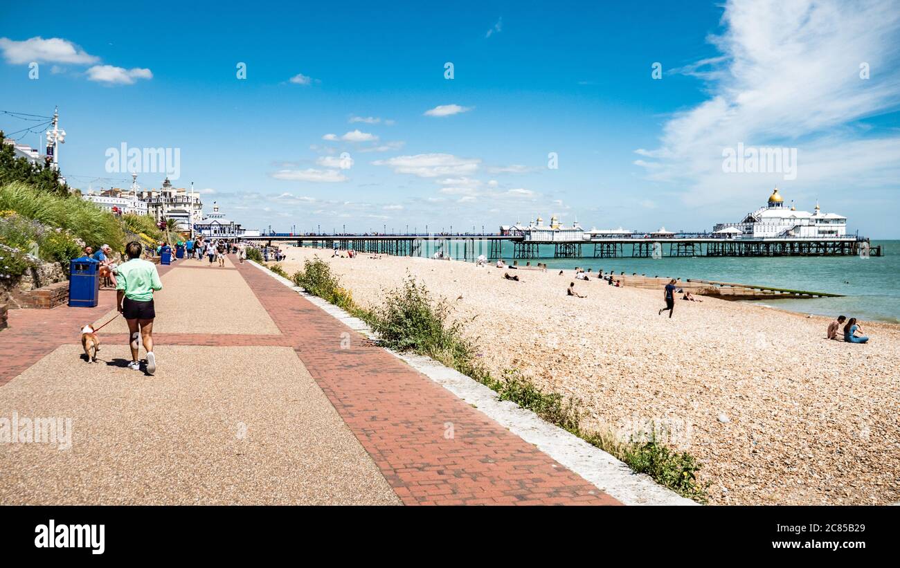Eastbourne, Inghilterra. Turisti e gente del posto si godono il caldo clima estivo sul lungomare della popolare cittadina di Sussex sulla costa meridionale. Foto Stock