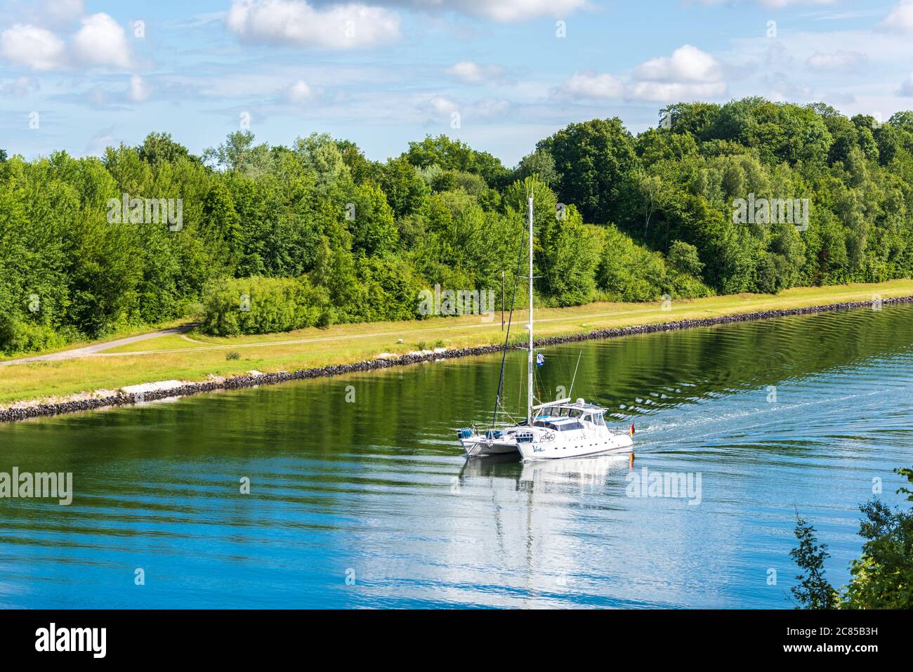 Ein SegelkatCatamaran passiert den Nord-Ostsee-Kanal an der Levensauer Hochbrücke a Richtung Nordse, Kiel-Suchsdorf Foto Stock