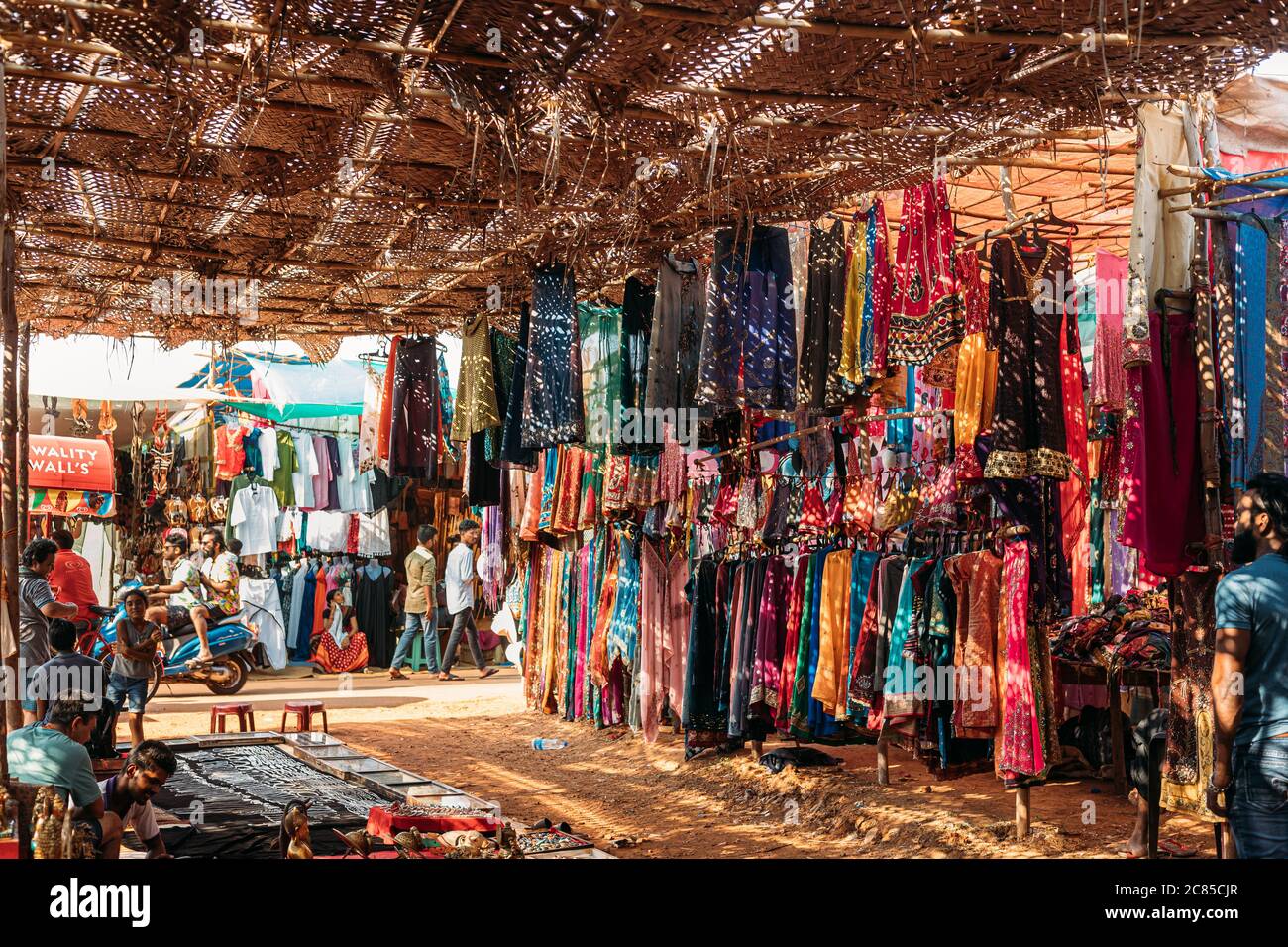 Anjuna, Goa, India. Man Seller vende souvenir e abiti indiani nel mercato di Anjuna. Foto Stock