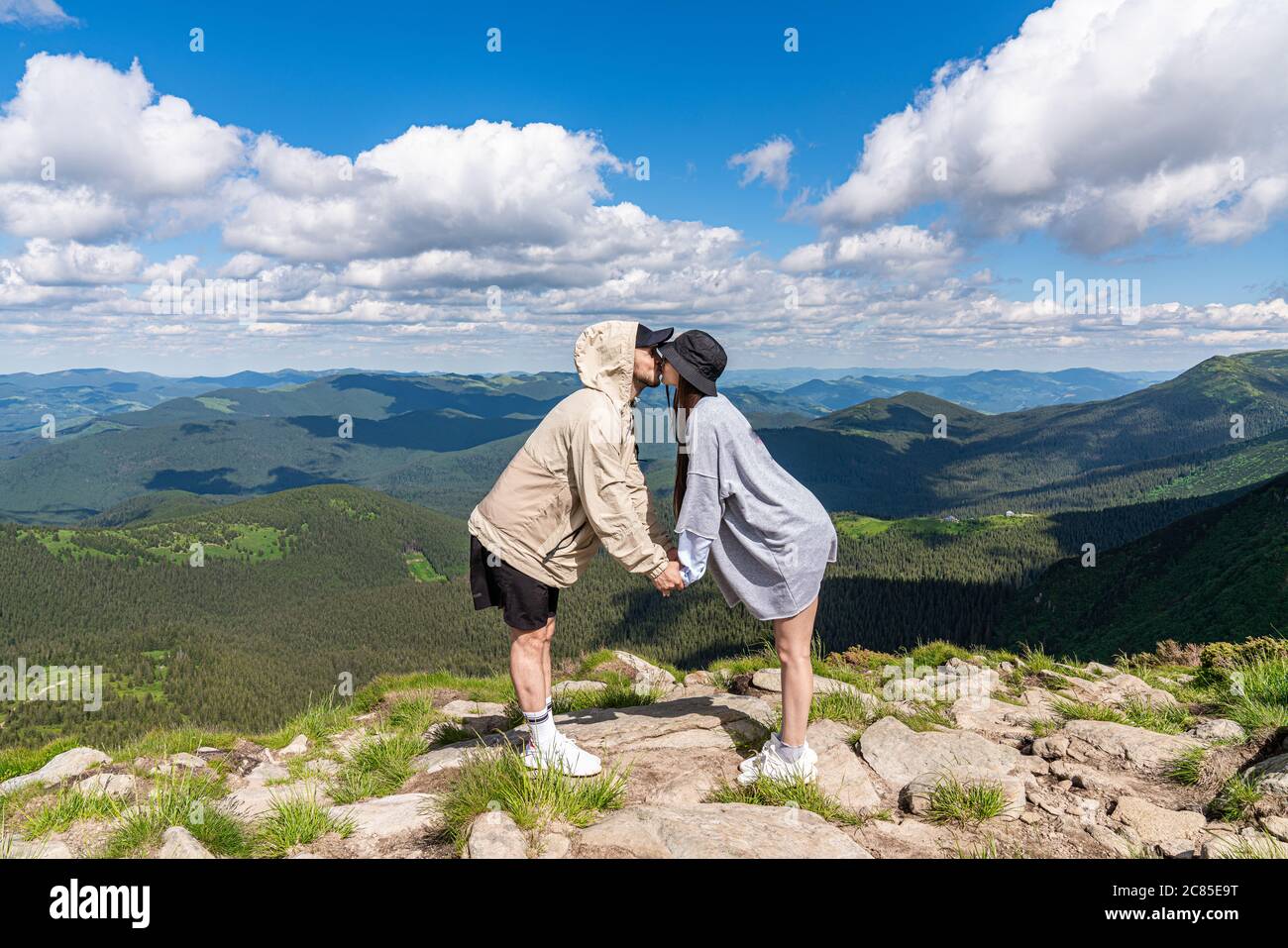 Coppia romantica baciante, montagne sullo sfondo. Sentimenti e relazioni concetto Foto Stock