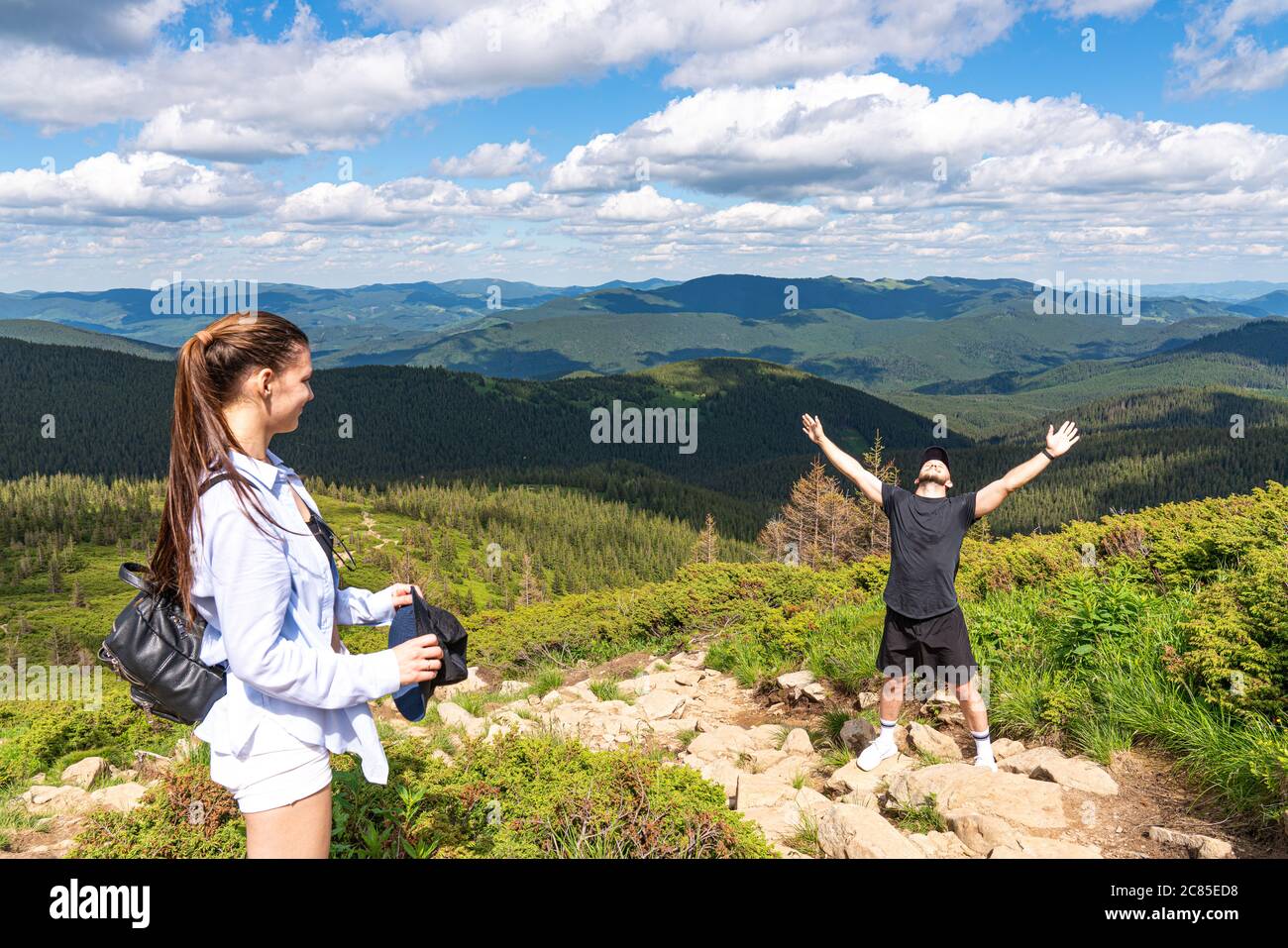 Felice uomo escursionista che festeggia sulla cima della montagna con le braccia in su Foto Stock