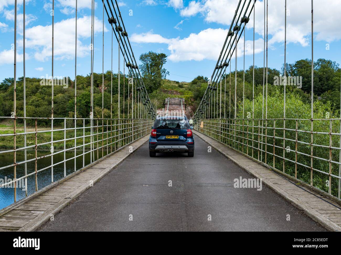 River Tweed, confine inglese/scozzese, Regno Unito, 21 luglio 2020. Bicentenario di Union Bridge: Il ponte celebra il suo 200° anniversario il 26 luglio. Fu il primo ponte sospeso veicolare nel Regno Unito. Al momento della sua costruzione, era il ponte sospeso in ferro battuto più lungo del mondo a 137 m. È ancora utilizzato regolarmente da pedoni, ciclisti e auto, ma le auto devono attraversare in un momento. Questa vista è dal confine scozzese. Una Skoda Yeti attraversa il ponte Foto Stock