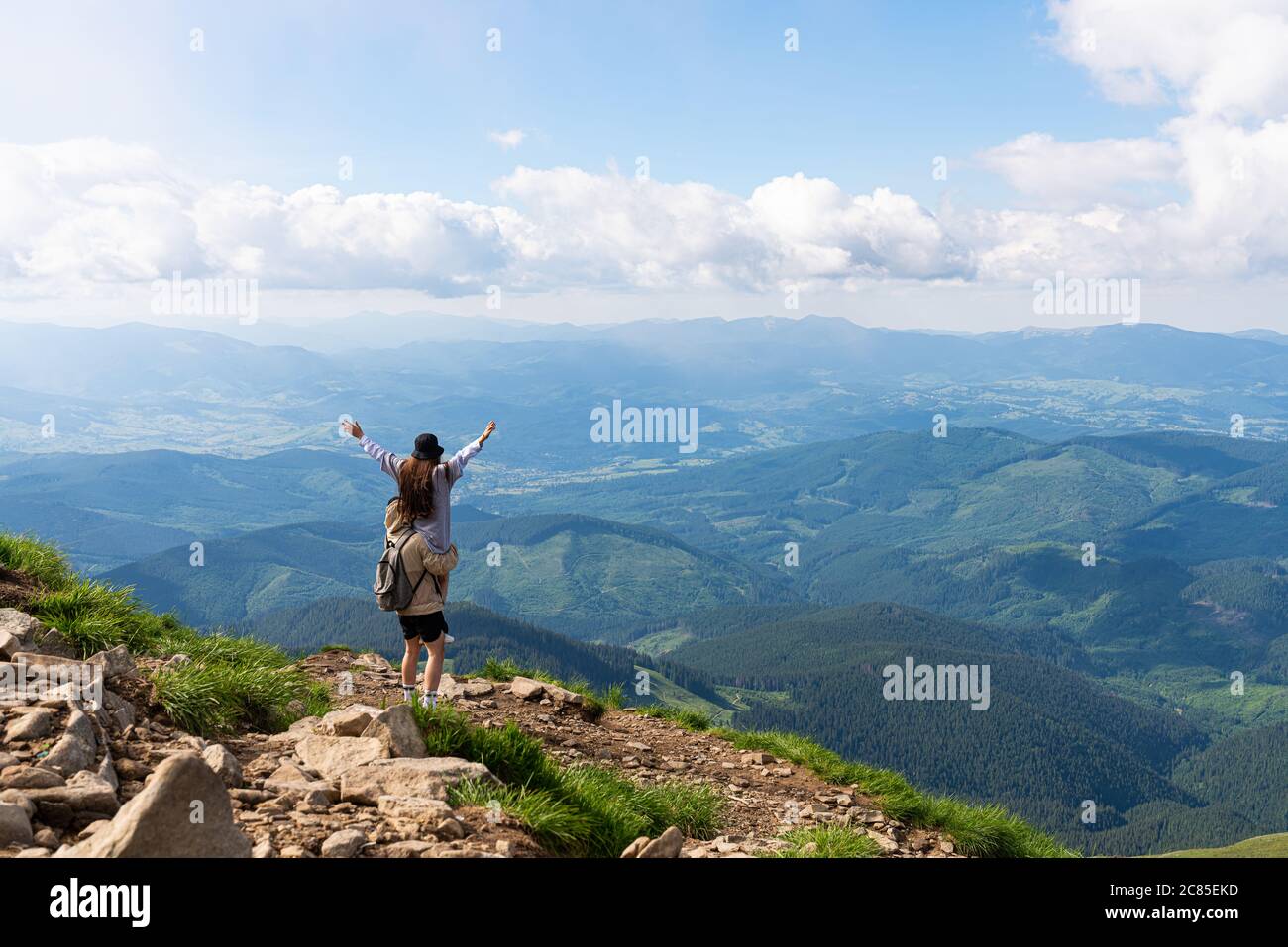 Gli escursionisti si rilassano in cima a una montagna e godono la vista della valle Foto Stock