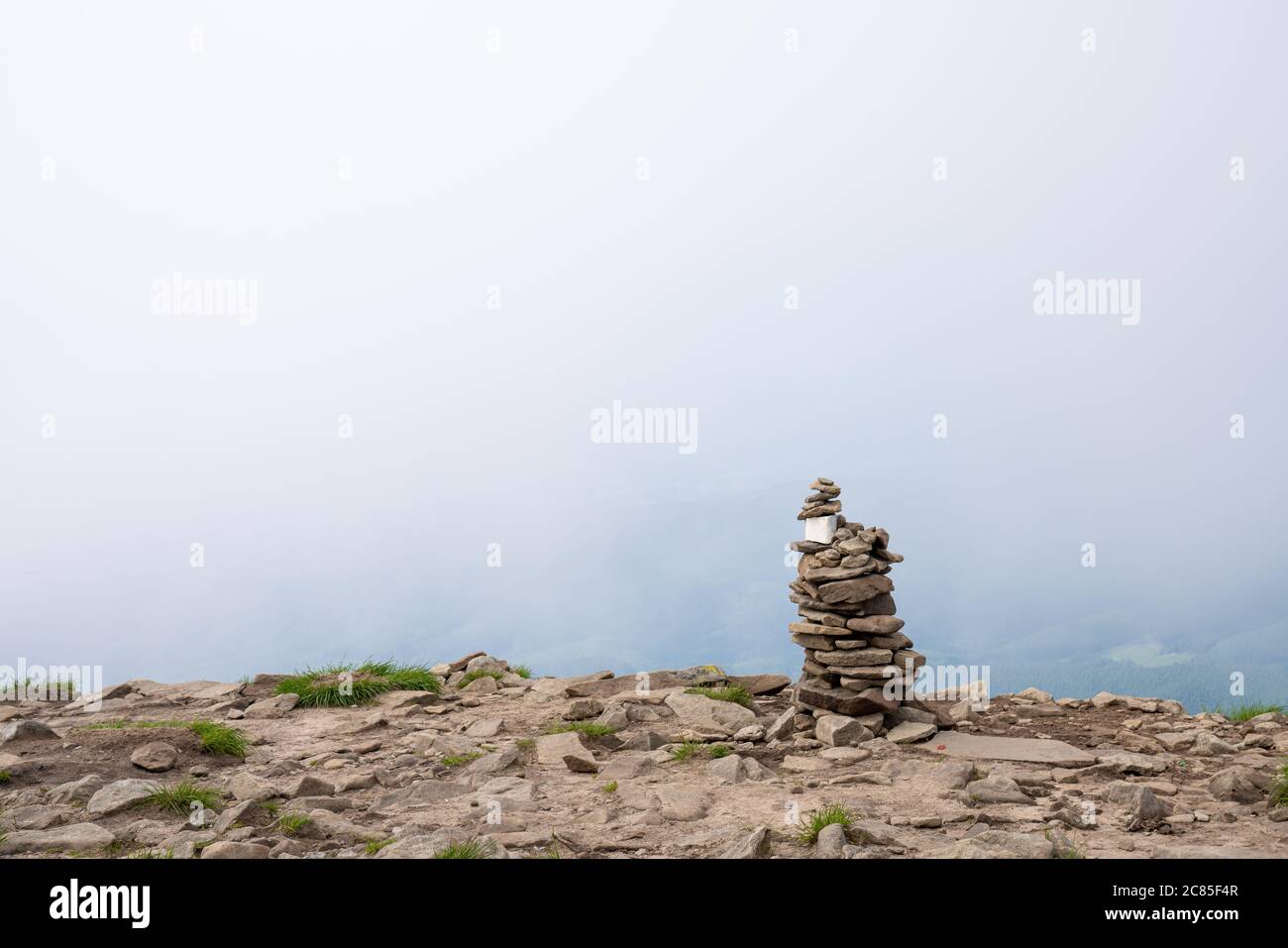 Pila di pietre sulla cima di una montagna su sfondo nuvole. Concetto di equilibrio e armonia Foto Stock