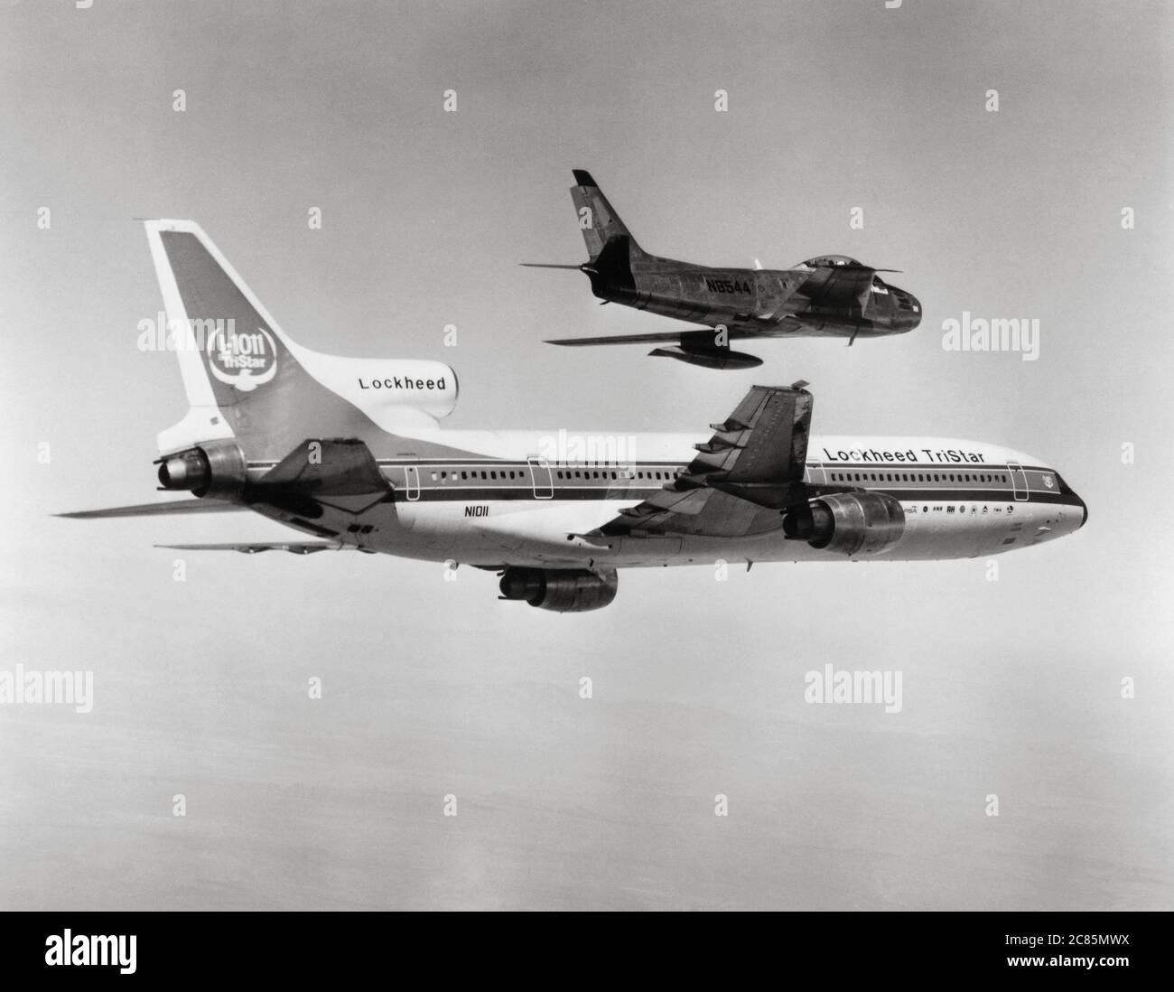 Volo inaugurale del prototipo Lockheed L-1011 TriStarmedio-lungo raggio aereo di linea a tre jet, accompagnato dal nordamericano F-86 'Sabre' aereo da combattimento a reazione transonica. 16 novembre 1976 Foto Stock