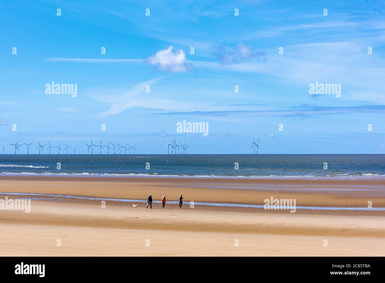 Persone che passeggiano sulla spiaggia di New Brighton sul Wirral sotto il sole. Foto Stock