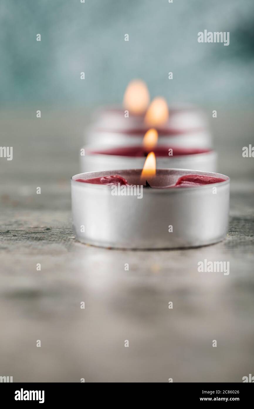 Piccole candele rosse che fiammeggiante sul terreno di cemento Foto Stock