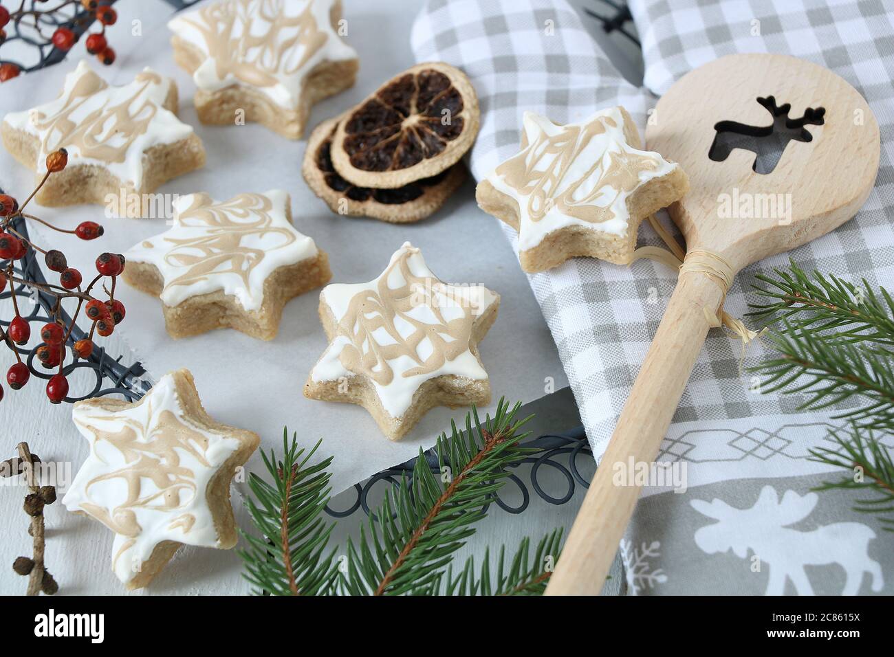 biscotti di natale, stelle di caffè alla cannella e cucchiaio di legno Foto Stock