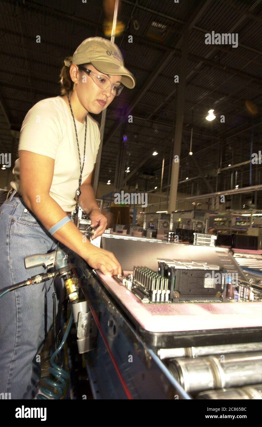 Round Rock, Texas USA luglio 2001: Lavoratrice tecnologica che indossa occhiali di sicurezza presso lo stabilimento di produzione Dell Server di Round Rock, Texas, dove server e workstation vengono assemblati per i mercati nordamericani. ©Bob Daemmrich Foto Stock
